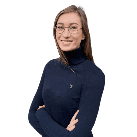 Frau mit Brille und dunklem Pullover lächelt in die Kamera.